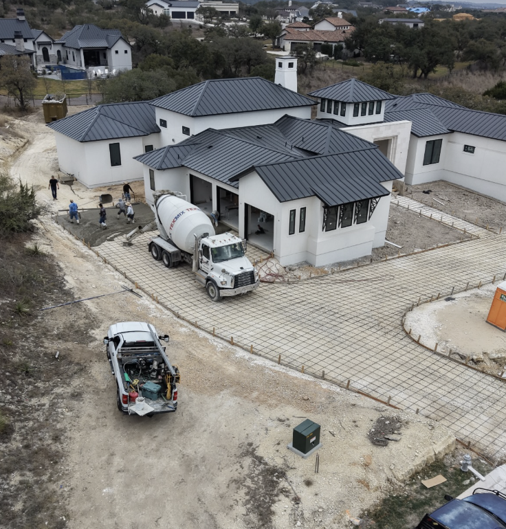Concrete crew pouring a driveway at a custom home